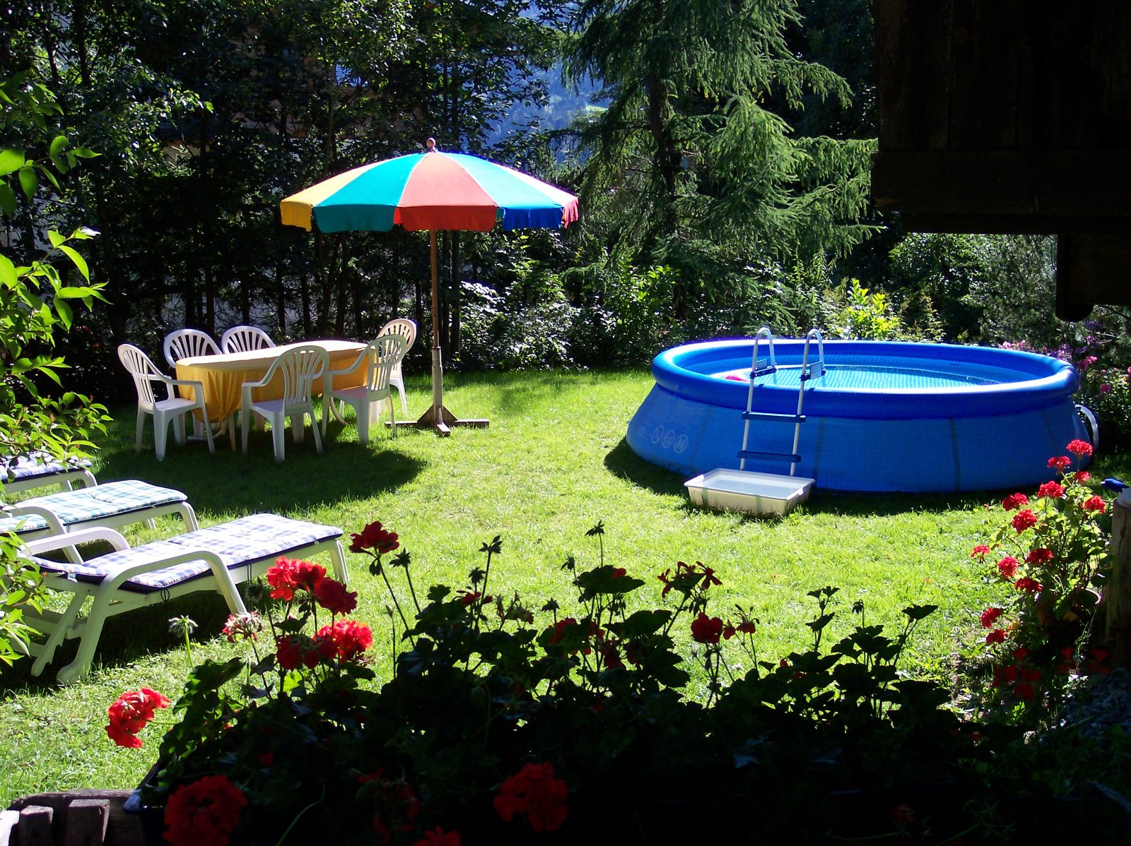 Großer Garten mit Liegestühlen und Sonnenschirm